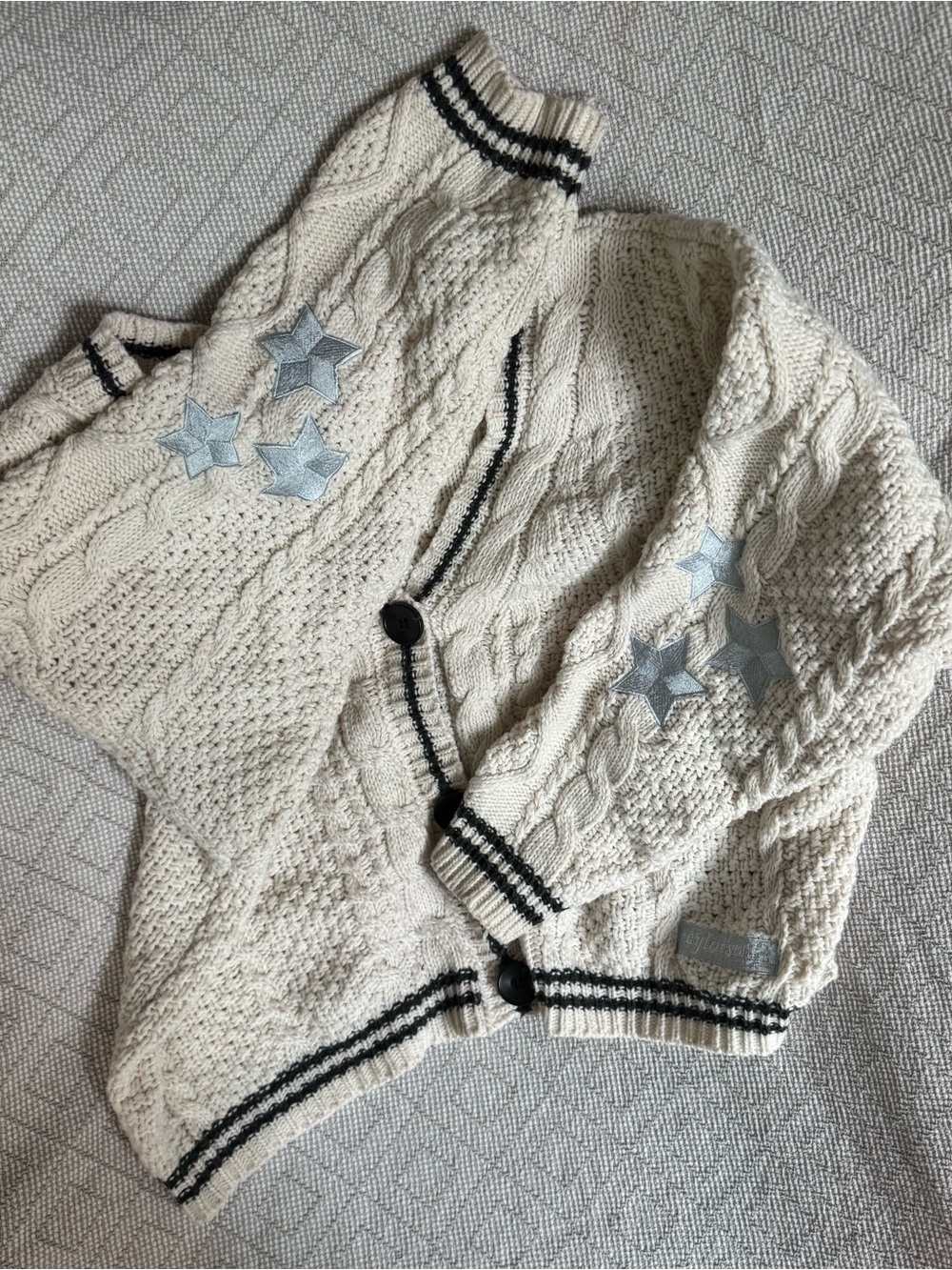 Taylor Swift Cream Cable Knit Cardigan with Black Trim and Silver Star Patches - Picture 2 of 5